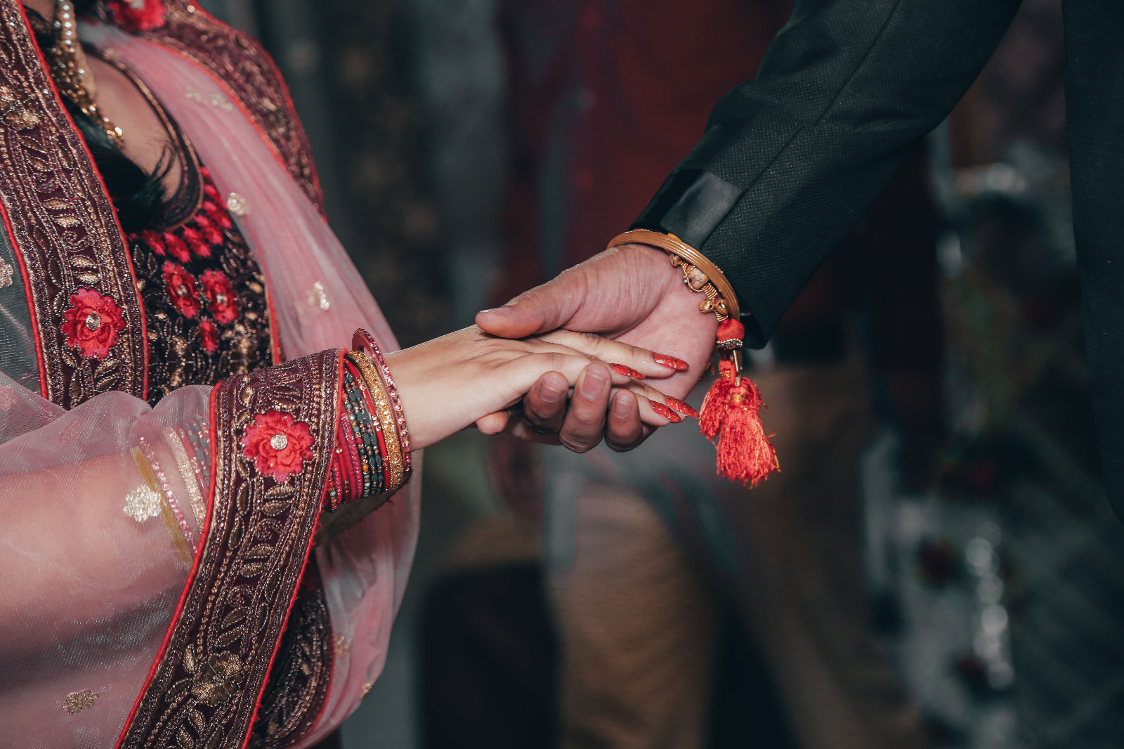 Traditional wedding hands adorned with bangles and gold embroidery